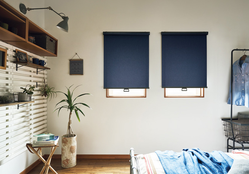 穏やかな光に包まれるベッドルームに「ロールスクリーン ラルクシールド(デニムクロス遮光)」の利用例の写真